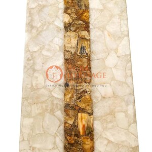 May include: Rectangular stone slab with a central band of brown and tan mosaic-like material. The surrounding stone is a light, off-white color, with a mosaic pattern. The image includes the text "ENRICHING WORLD AROUND YOU".
