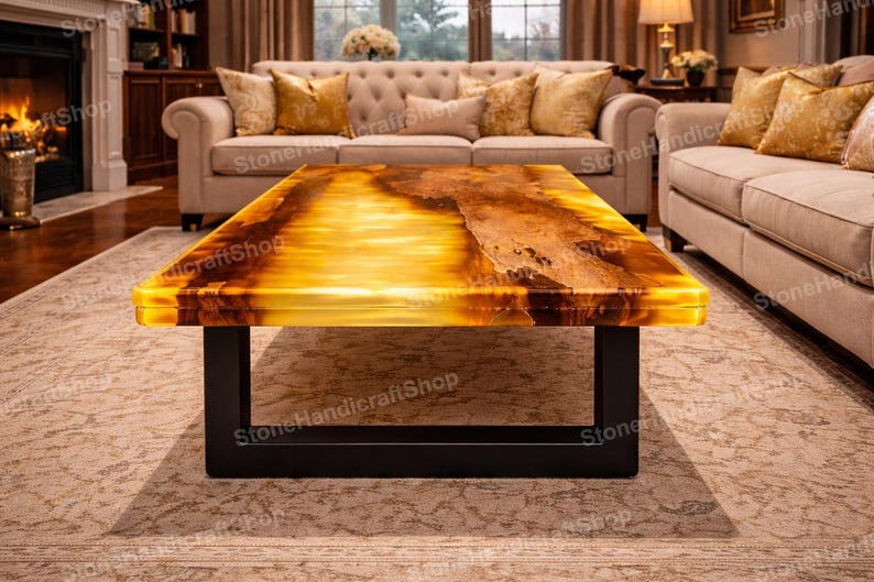 May include: A rectangular coffee table with a glowing amber-colored top and a black metal base. The table's surface has a natural, textured appearance, and it is set in a living room with neutral-toned furniture.