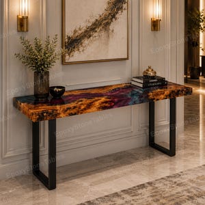 May include: A rectangular console table featuring a polished surface with a swirling pattern of deep purple, blue, and amber tones. The table is supported by two black metal U-shaped legs. A glass vase with greenery and a stack of books sit on top.