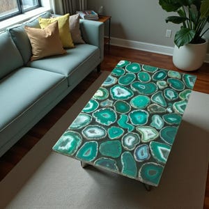 May include: Rectangular coffee table with a top made of polished, irregularly shaped green and white agate slices. The table has a dark metal frame and sits on a light-colored rug. The table is in a living room setting.