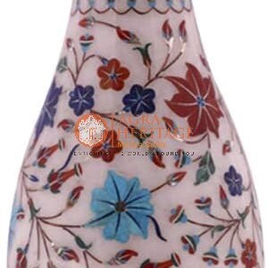 May include: White marble vase with detailed floral inlay. The vase showcases red, blue, and green floral patterns. It has a broad base and a slender neck, standing approximately 30 cm tall.
