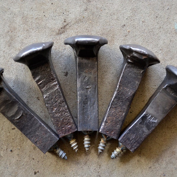 May include: Five antique railroad spikes with screw-on bases. The spikes are made of metal and have a dark gray finish. The screw-on bases are made of metal and have a silver finish.