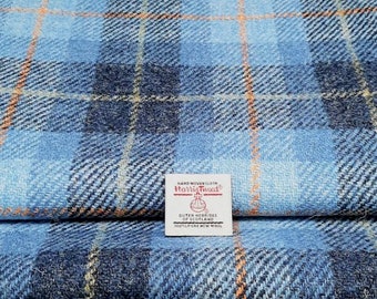 May include: Blue and orange plaid fabric with a label that reads "Handwoven Cloth Harris Tweed Outer Hebrides of Scotland 100% Pure New Wool"