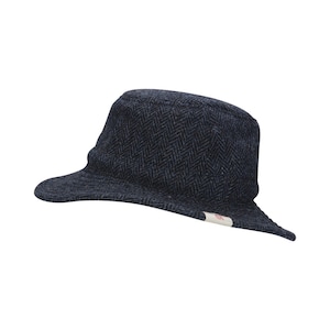 K&ouml;nnte beinhalten: Ein blauer und schwarzer Hut aus Tweed mit Fischgratmuster und einem kleinen wei&szlig;en Etikett an der Seite.