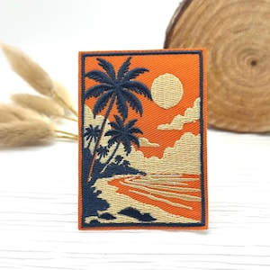 Może przedstawiać: Haftowana naszywka przedstawiająca tropikalną scenę na plaży. Projekt zawiera palmy, słońce i chmury na pomarańczowym tle. Naszywka ma granatową obwódkę i akcenty i jest prostokątna.