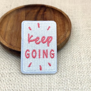 Parche bordado termoadhesivo con la frase "Sigue adelante con una actitud positiva".