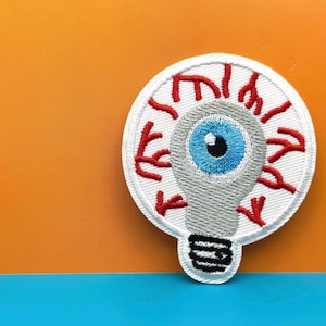 Augapfel Glühbirne Aufnäher: Lustig gesticktes Bügelbild