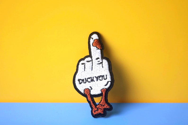 May include: White embroidered patch of a duck giving the middle finger with the text "Duck You" in black.