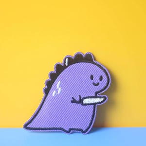 Purple Dinosaur Holding Knife Embroidered Iron-On Patch
