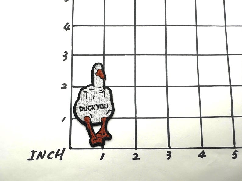 May include: White embroidered patch of a middle finger with the text "Duck You" in black. The finger is wearing a red and orange nail polish and has red and orange feet.