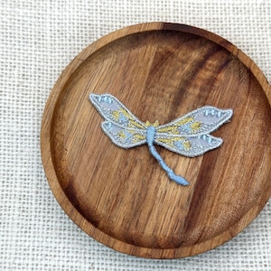 Geborduurde libelle-strijkpatch: gouden en zilveren appliqué