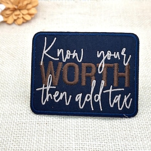 May include: A rectangular navy blue embroidered patch featuring the white cursive text Know your and then add tax, with the word WORTH stitched in large brown block letters in the centre. The patch has a dark blue border and a fabric texture.