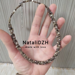 May include: A brown and gold necklace and bracelet set with white beads. The necklace has a silver clasp. The text "NataliDZH made with love" is visible in the image.