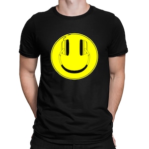 Könnte beinhalten: Schwarzes T-Shirt mit einem gelben Smiley, der Kopfhörer trägt.