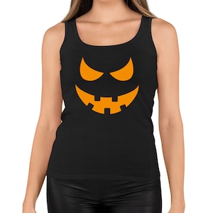 May include: Black vest top with an orange jack-o'-lantern face design. The graphic features triangular eyes and a jagged-tooth grin. A sleeveless top, ideal for Halloween or themed events.