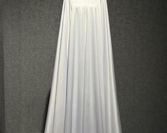 May include: A long, white hooded cloak with a black decorative clasp at the neckline. The cloak is made of a flowing fabric and is displayed on a mannequin. The background is a solid gray.
