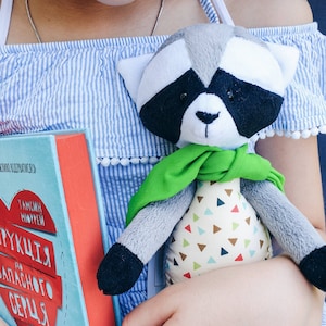 Stuffed raccoon animal with green scarf. Woodland nursery toys decor. Cute raccoon with moving paws