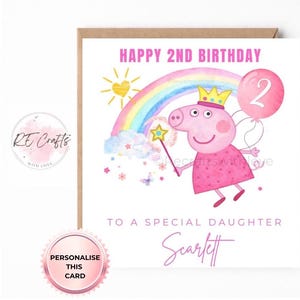 May include: A square birthday greeting card featuring a pink pig character wearing a yellow crown and dress, holding a star wand. The design includes a rainbow, a sun, clouds, and a pink balloon with the number 2. Text reads HAPPY 2ND BIRTHDAY TO A SPECIAL DAUGHTER SCARLETT.