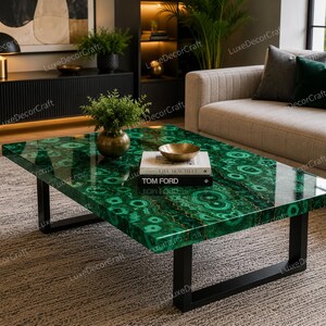 Può includere: Un tavolino rettangolare con un piano in malachite verde brillante e gambe in metallo nero. Il tavolo presenta una finitura lucida e un motivo unico. Una ciotola d'oro e dei libri sono sul tavolo. Il tavolo si trova in un soggiorno.