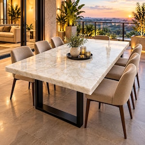 May include: A rectangular dining table with a polished white quartz stone top and a black metal U-shaped base, surrounded by eight upholstered beige chairs with dark wooden legs. A round black tray holds a small potted plant and two candle holders.
