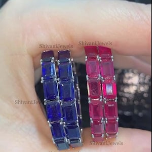 May include: Two pairs of gemstone hoop earrings. One pair features blue rectangular stones, the other features pink rectangular stones. The earrings are held in a hand. The text "ShivaniJewels" is visible on the image.