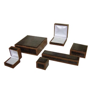 May include: Assortment of six brown faux leather jewelry boxes in various sizes and shapes. The boxes have a textured, crocodile-like pattern.