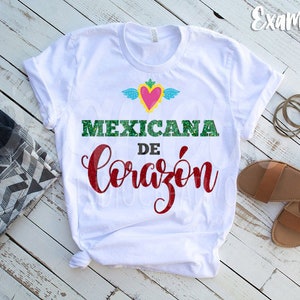 May include: White t-shirt with a green, red, and yellow heart with wings and the text "MEXICANA DE CORAZ&Oacute;N" in green and red glitter.