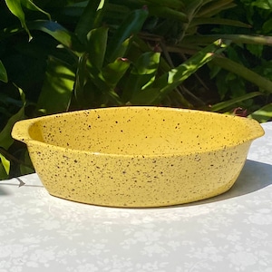 May include: A yellow speckled oval baking dish with black speckles. The dish is made of ceramic and has a glossy finish.