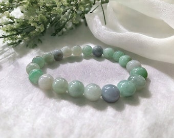 May include: A jade bracelet with green and white beads. The bracelet is made of natural jade and is a beautiful piece of jewelry.