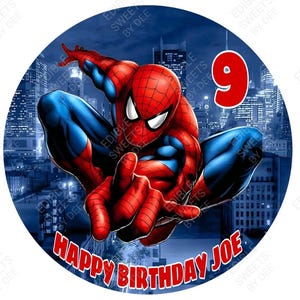 May include: A round edible cake topper featuring a red and blue Spiderman character in a city skyline setting. The text "Happy Birthday Joe" is printed in red on the bottom of the cake topper. The number 9 is printed in red on the right side of the cake topper.