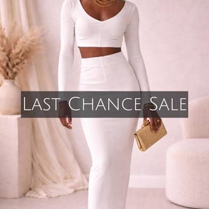 May include: A woman wearing a white two-piece outfit, consisting of a long-sleeved crop top and a midi skirt. She is holding a gold clutch. The text "LAST CHANCE SALE" is displayed on the image.