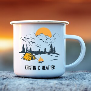 May include: White enamel camping mug with a mountain scene, a tent, a campfire, and the text "KRISTIN & HEATHER".