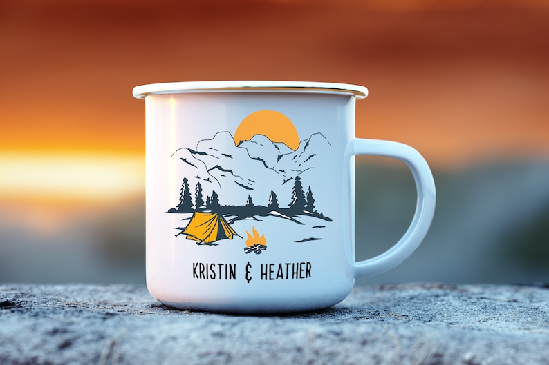 May include: White enamel camping mug with a mountain scene, a tent, a campfire, and the text "KRISTIN & HEATHER".