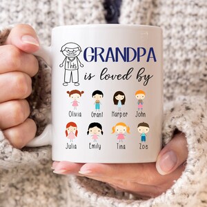 May include: White ceramic mug with a black and white illustration of a person with the text "Grandpa is loved by" and a row of eight black and white illustrations of children with names below each illustration. The names are Olivia, Grant, Harper, John, Julia, Emily, Tina, and Zoe.