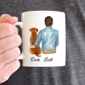Puede incluir: Taza de cer&aacute;mica blanca con una ilustraci&oacute;n a la acuarela de una persona y un perro. La persona lleva una camisa azul y pantalones color caqui, con el perro a su lado. Los nombres "Clark Scott" est&aacute;n impresos debajo.