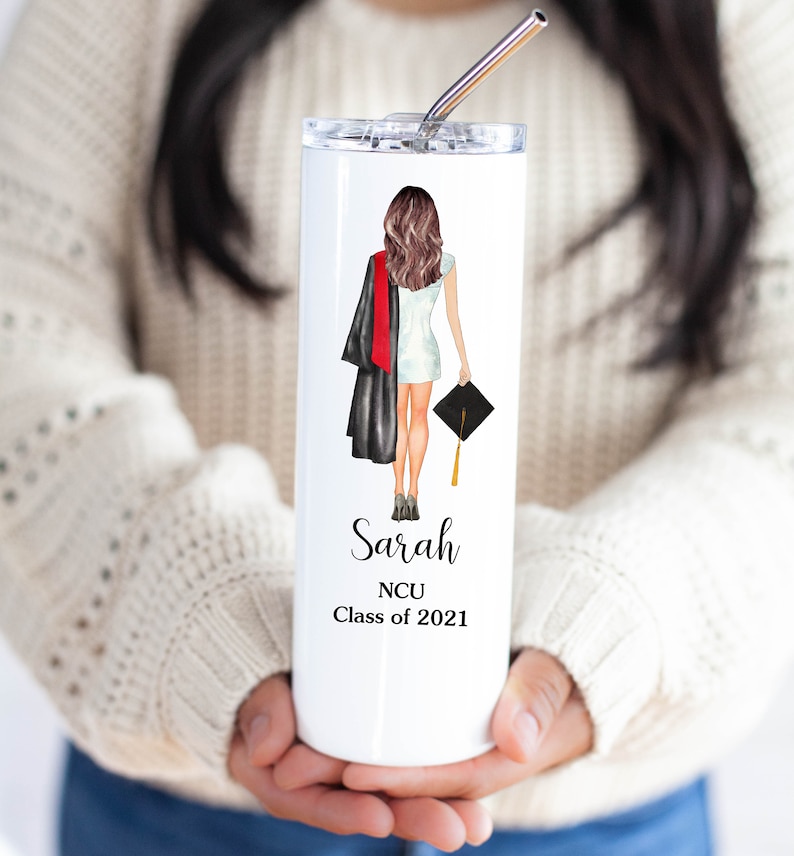 K&ouml;nnte beinhalten: Ein wei&szlig;er Edelstahlbecher mit einer Illustration von einer Abschluss-Kappe und -Gown, dem Namen "Sarah" und dem Text "NCU Class of 2021".