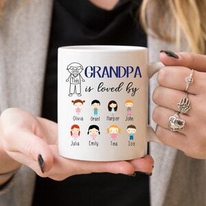 May include: White ceramic coffee mug with a black and white illustration of a grandpa and the text "Grandpa is loved by". Below the text are 8 stick figure illustrations of children with their names printed below each figure: Olivia, Grant, Harper, John, Julia, Emily, Tina, Zoe.