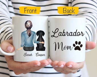 May include: White ceramic mug with a black and white illustration of a woman with a black labrador retriever. The text "Sarah Cooper" is printed on the front of the mug. The back of the mug has the text "Labrador Mom" with a black paw print.