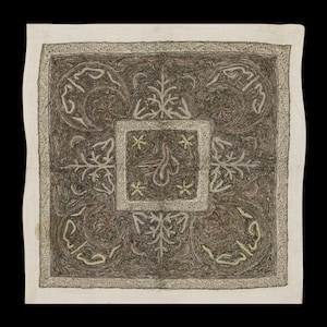 May include: A square textile with detailed embroidery. The central design is a square with floral and star motifs, surrounded by swirling patterns and script. The border is a lighter colour, framing the dark, detailed central design.
