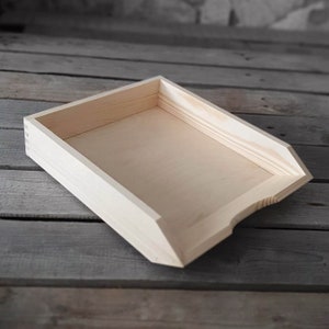 Può includere: Un vassoio organizzatore da scrivania in legno naturale con un bordo anteriore inclinato. Il vassoio è in legno grezzo e pronto per essere dipinto o tinto.