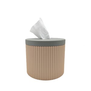 Pode incluir: Caixa de lenços de papel cilíndrica com corpo canelado cor de pêssego e tampa cinza. Os lenços brancos são puxados de cima. O design é moderno e minimalista, adequado para uso doméstico ou escritório.