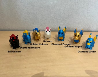 May include: A collection of eight small, colorful, 3D printed figurines of mythical creatures. The figurines include a unicorn, a golden unicorn, a diamond dragon, a golden dragon, a diamond griffin, a diamond unicorn, and an evil unicorn.