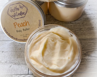 May include: A glass jar filled with a creamy peach-colored body butter. The jar has a label that reads "Jessy You Creations" and "Peach Body Butter 4.5 oz / 128 g Net Wt" with a website address.