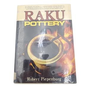 May include: A book cover for "RAKU POTTERY" showing a pottery piece in a kiln. The title is in red and yellow, with the author's name, Robert Piepenburg, at the bottom. The background features flames, suggesting the firing process.