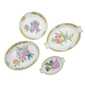 May include: Set of four porcelain dishes with floral designs in shades of pink, yellow, green, and blue. The dishes have a white background and green and gold trim.