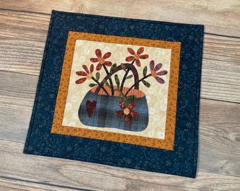 Decorazione da parete a forma di cestino di fiori piccolo, modello Flossie's Flowers, realizzata con tessuto trapuntato, dimensioni 45,7 x 43,2 cm (18" x 17"), con passante per appenderla.