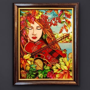 Pu&ograve; includere: Un dipinto su vetro raffigurante una donna che suona il violino circondata da foglie autunnali. La donna ha lunghi capelli rossi e indossa un vestito bianco. Le foglie sono in tonalit&agrave; di rosso, arancione, giallo e verde.