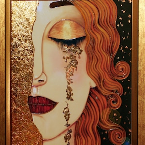 Puede incluir: Una pintura enmarcada de la cara de una mujer con los ojos cerrados y una sola l&aacute;grima hecha de pan de oro. El cabello de la mujer es rojo y fluido, y el fondo es negro con motas doradas.