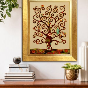 May include: A framed artwork featuring a stylized tree with a brown trunk and branches, decorated with colorful circles and swirls. The tree is set against a beige background and framed in a gold frame.