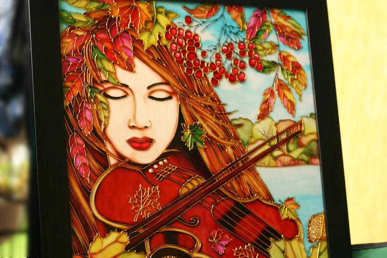 Pu&ograve; includere: Un dipinto su vetro raffigurante una donna che suona il violino. La donna ha lunghi capelli castani e indossa un vestito rosso. Il violino &egrave; rosso e dorato. Lo sfondo &egrave; un cielo blu con bacche rosse e foglie autunnali.